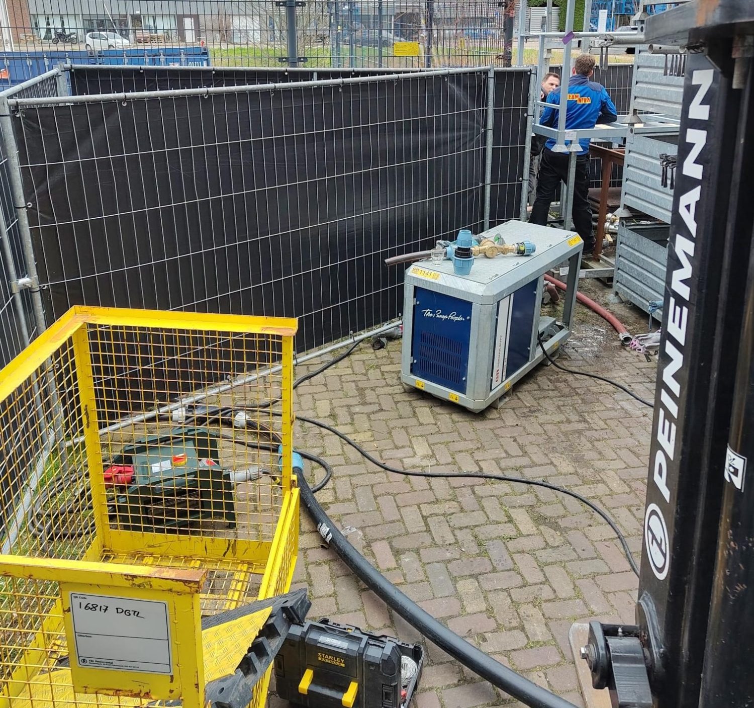 Elektrische Gorman-Rupp pompset met slangen op een afgezette bouwplaats